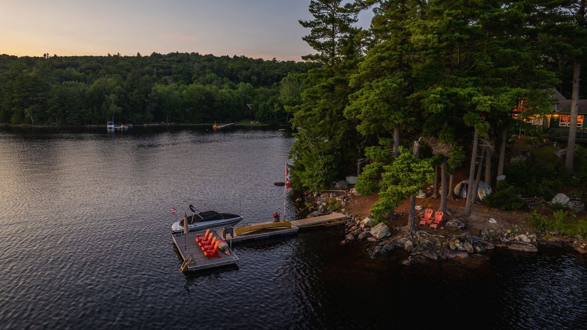 waterfront cottage on little redstone lake with a boat and a dock.